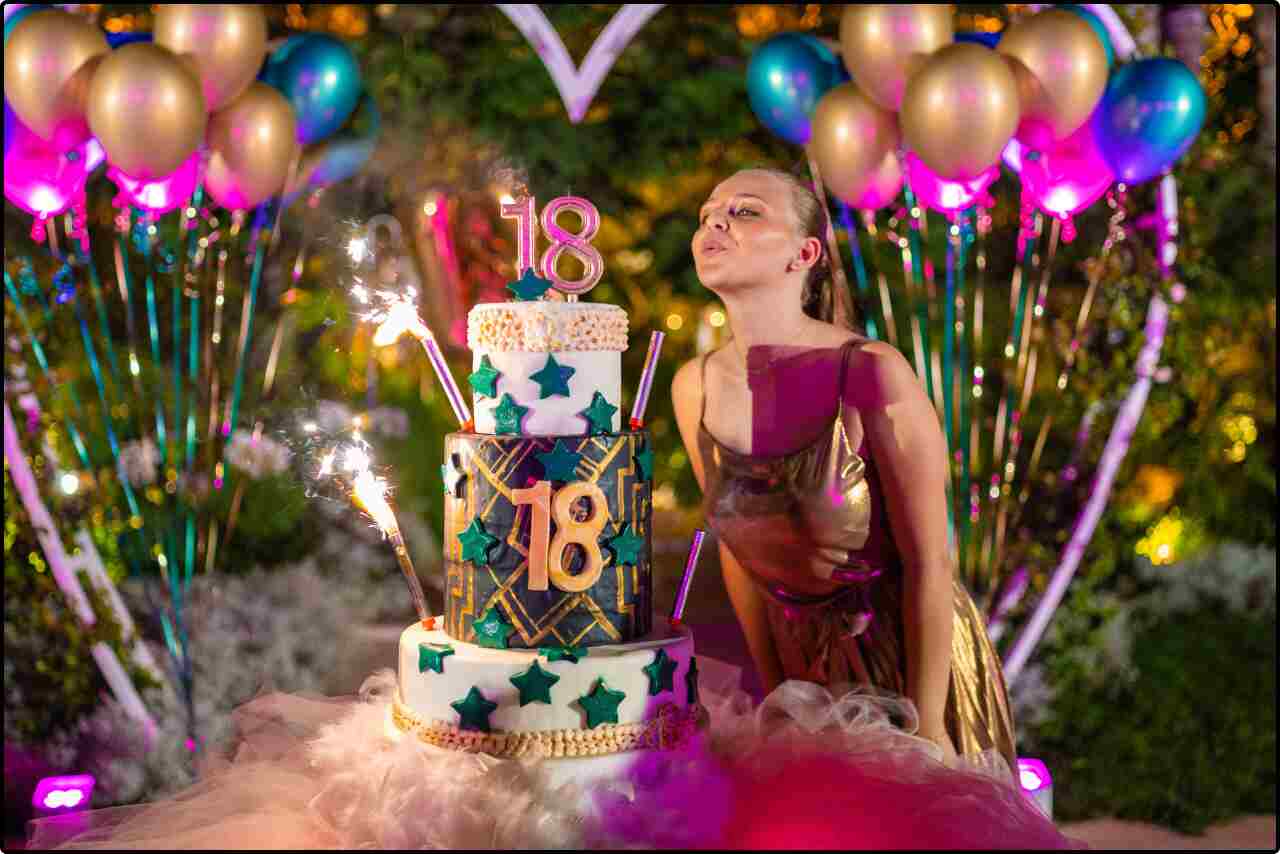 Close-up of a woman's delighted face as she blows out candles on her birthday dessert